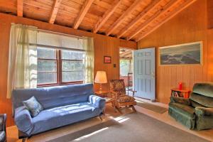 sala de estar con sofá azul y silla en Panther Pond Cabin with 200 Ft Sand Beach and Dock!, en Raymond