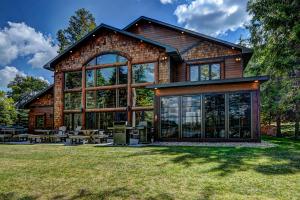 a house with a large window on a lawn at Whispering Pines Lodge: 9 Bedroom in Eagle River