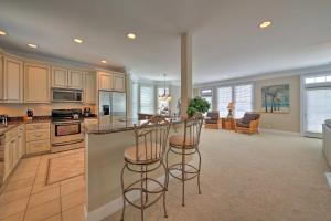 a large kitchen with two bar stools and a counter at Manteo Waterfront Resort Home with 30-Ft Dock! in Manteo