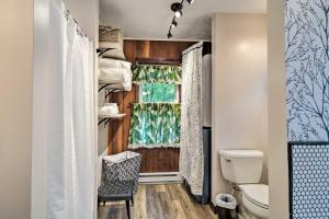 Un baño con inodoro y ventana. en Dog-Friendly Home Near Crystal Mtn and Outdoor Rec!, en Interlochen