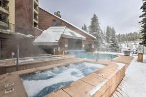a swimming pool with snow on the ground next to a house at Iron Horse Studio with Resort Amenities Walk to WP! in Winter Park