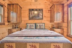 1 dormitorio con 1 cama con paredes y ventanas de madera en Mill Spring Cabin Near Parker-Binns Winery!, en Mill Spring