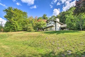 a house on a hill with a large grass field at House with Balcony about 5 Mi to Cranmore Resort! in Bartlett
