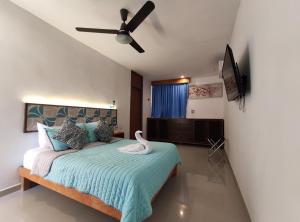 a bedroom with a bed with a swan on it at Kai Hotel Boutique Adults Only in Holbox Island