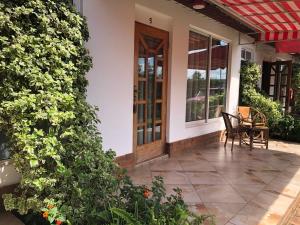 um pátio com uma mesa e cadeiras numa casa em Bird of Paradise Eco Lodge em Arusha