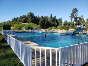 una grande piscina con persone in acqua di Resort Amanda a Quillón