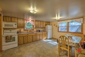 a kitchen with wooden cabinets and a white refrigerator at Catskill Mtn Home with Deck about 1 Miles to Zoom Flume! in East Durham