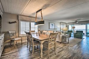 a dining room and living room with a table and chairs at Lavish Beachfront Condo with Balcony and Pool Access in New Smyrna Beach