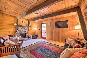 a living room with a fireplace and a tv at Log Cabin Retreat with Deck Near Big Bear Lake! in Big Bear City
