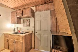 a small kitchen with a sink and a door at Log Cabin Retreat with Deck Near Big Bear Lake! in Big Bear City