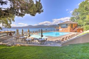 a swimming pool with tables and chairs next to the water at Hot Tub and Lake Tahoe Views Kings Beach Lodge in Kings Beach