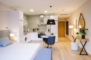 a bedroom with a bed and a table and a kitchen at Suites Castellón in Castellón de la Plana