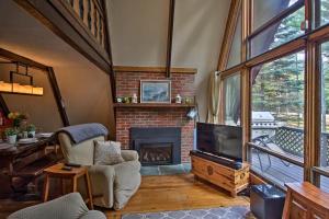 ein Wohnzimmer mit einem Kamin und einem Stuhl in der Unterkunft Ski Chalet on Saco with Mtn View 2 Mi To Attitash in Bartlett
