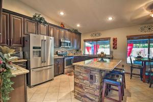 una cocina con electrodomésticos de acero inoxidable y una isla de piedra en Red Mountain Mesa Oasis Pool, Bar and Game Room!, en Mesa