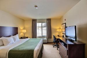 a hotel room with a bed and a flat screen tv at Cobblestone Inn & Suites - Brillion in Brillion