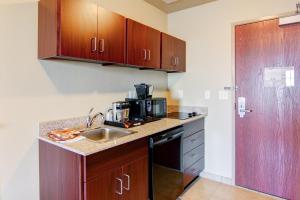 a small kitchen with a sink and a microwave at Cobblestone Inn & Suites - Brillion in Brillion