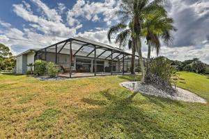 a house with a palm tree in front of it at Pet-Friendly Fort Myers Home with Heated Pool! in North Fort Myers