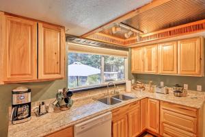 a kitchen with wooden cabinets and a sink and a window at Quaint Priest Lake Cabin with Patio Less Than 1 Mi to Lake! in Vans Corner