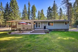 a small house with a picnic table and a patio at Quaint Priest Lake Cabin with Patio Less Than 1 Mi to Lake! in Vans Corner