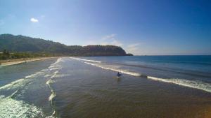 a person standing in the water on a beach at Costa Rica Surf Camp by SUPERbrand in Jacó