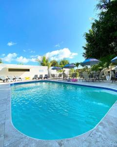 ein großer blauer Pool mit Stühlen und Sonnenschirmen in der Unterkunft Hotel Las Palmas de OSA in Ciudad Cortés