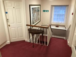 baño con tocador con taburete y espejo en Crown Hotel, en Pwllheli