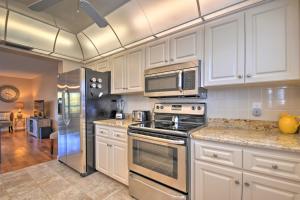 a kitchen with white cabinets and a stainless steel refrigerator at Indian Shores Townhome with Pool Access and Kayaks! in Clearwater Beach
