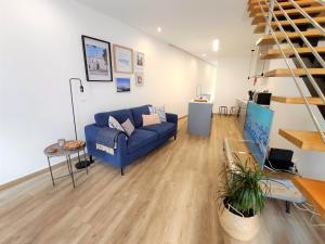 a living room with a blue couch and a staircase at Casa da Mouraria in Faro