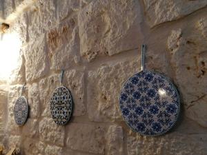 three blue and white plates hanging on a stone wall at Il Casolare nel relax in Ostuni