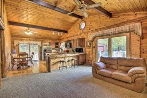 a living room with a couch and a kitchen at Pet-Friendly Raystown Lakefront Cabin with BBQ Grill in Hesston