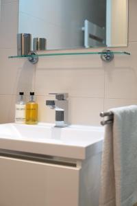 a bathroom with a white sink with a mirror at Belville Luxury Apartment in Belgrade