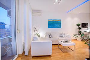 a living room with a white couch and a table at Belville Luxury Apartment in Belgrade