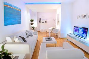 a white living room with a white couch and a tv at Belville Luxury Apartment in Belgrade