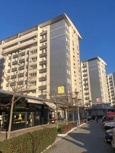 a tall building with cars parked in front of it at Belville Luxury Apartment in Belgrade