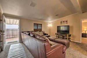 a living room with a couch and a flat screen tv at Page Home with Patio and BBQ, 3 Mi to Lake Powell! in Page