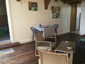 een patio met een tafel en stoelen op een veranda bij Bungalow Sea Brise 2 personnes in Saint-François