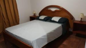 Duplex en Valle Hermoso في فالي هيرموسو: غرفة نوم بسرير كبير مع لوح رأس خشبي