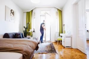 Un uomo in piedi alla porta di una camera da letto di Huge Central Designer Loft with Tyrolean Touch , 160m2 a Innsbruck