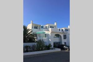 a white house with a car parked in front of it at Muramaris in Salema