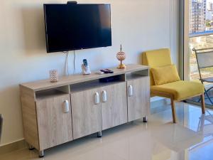 a living room with a television and a chair at Apartamento Panoramico Milano in Barranquilla