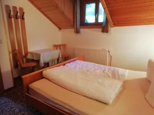 a bedroom with a bed and a table and a window at Berghof Knabl in Arzl im Pitztal