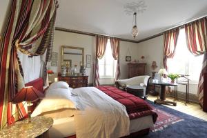 a bedroom with a bed and a desk and a chair at La Maison D'hôtes du Parc in Ronchamp