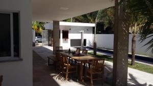 a wooden table and chairs on a patio at KiteBar Hotel in Cumbuco