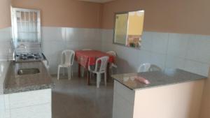 a kitchen with a table and a table and chairs at Casa Morada da Praia 1 in Peroba +32 photos