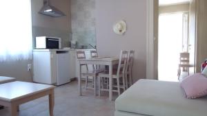 a living room with a kitchen and a table with chairs at House of Garden in Dhráganon