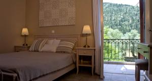 a bedroom with a bed and a balcony with a view at House of Garden in Dhráganon