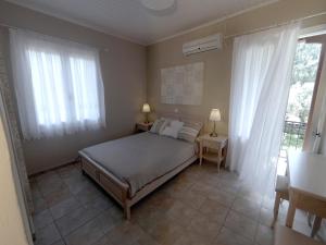 a bedroom with a bed and two lamps and a window at House of Garden in Dhráganon
