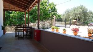 a patio with a table and chairs and potted plants at House of Garden in Dhráganon