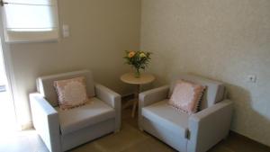 two chairs and a table with a vase of flowers at House of Garden in Dhráganon