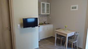 a small kitchen with a small table and a refrigerator at House of Garden in Dhráganon